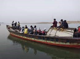 মোটরসাইকেল ট্রলারে ঝুঁকি নিয়ে পদ্মা নদী পার হচ্ছে