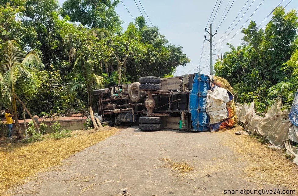 শরীয়তপুর চাঁদপুর সড়কে পণ্যবাহী ট্রাক উল্টে যান চলাচল বন্ধ